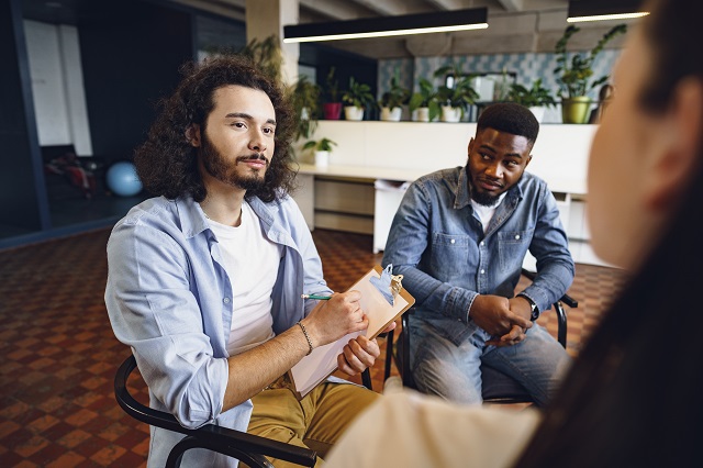 Young people sitting in a circle and having a group discussion